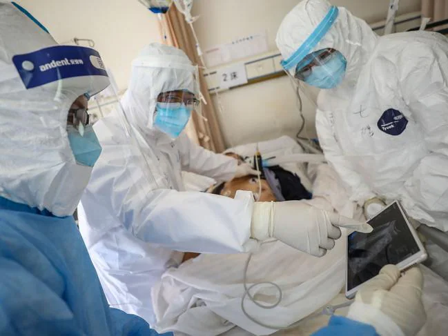 Lekarz bada pacjenta z Covid-19 w szpitalu Czerwonego Krzyża Wuhan w Wuhan.  Zdjęcie: AFP