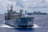 An Australian warship in the open ocean with another one behind it.